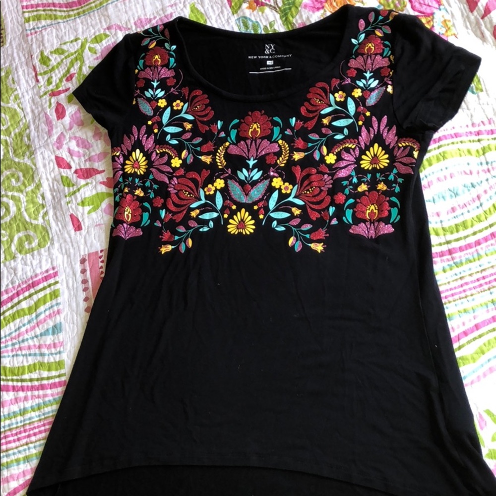 A blouse with flower and accents on the front.